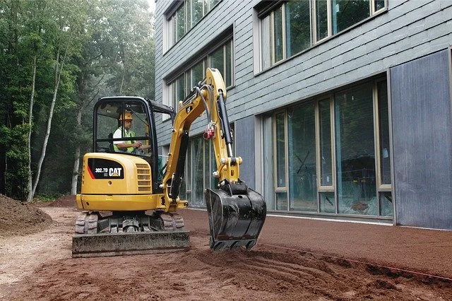 Yellow backhoe with hydraulic piston arm 